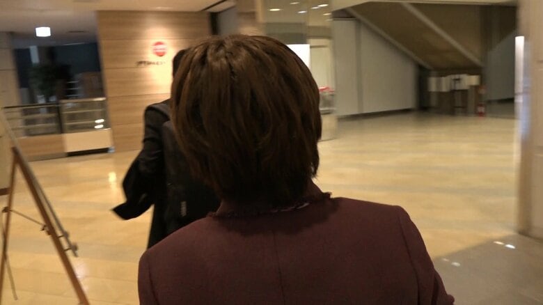 記者の質問に対し無言で歩き続ける山谷議員