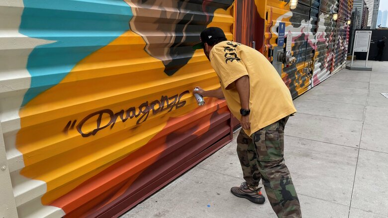 署名をして作品を完成させるDragon76さん