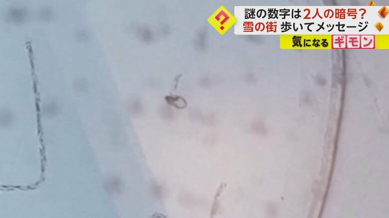 雪上にさらに続けてメッセージ描き始める人