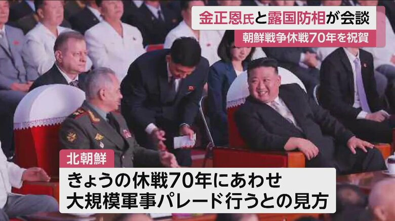 並んで座り、ショイグ国防相に笑顔を見せる金正恩総書記