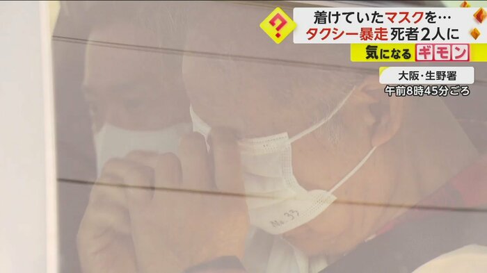 大阪・生野署から出てくるパトカーの中。男はマスクで顔を隠す