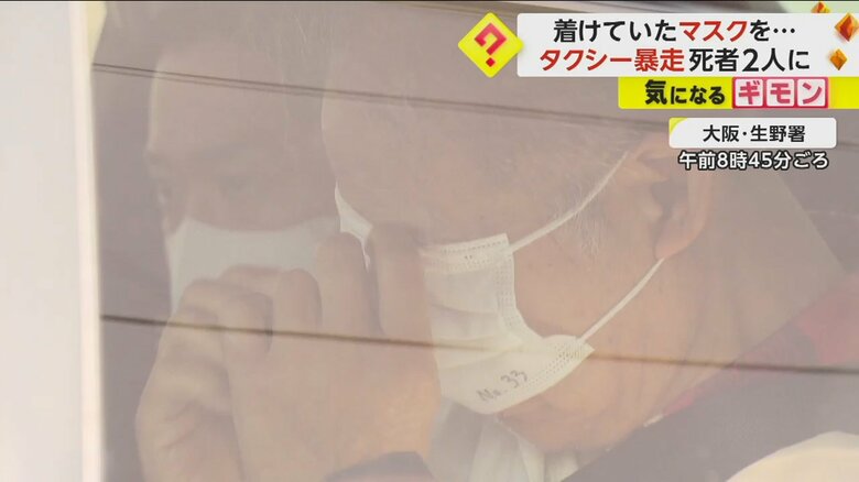 大阪・生野署から出てくるパトカーの中。男はマスクで顔を隠す