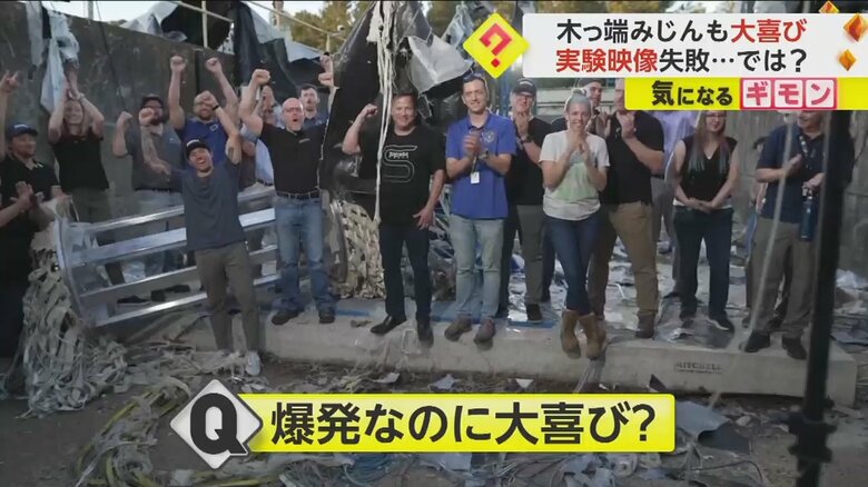 実験の結果に手を叩いて喜ぶ関係者