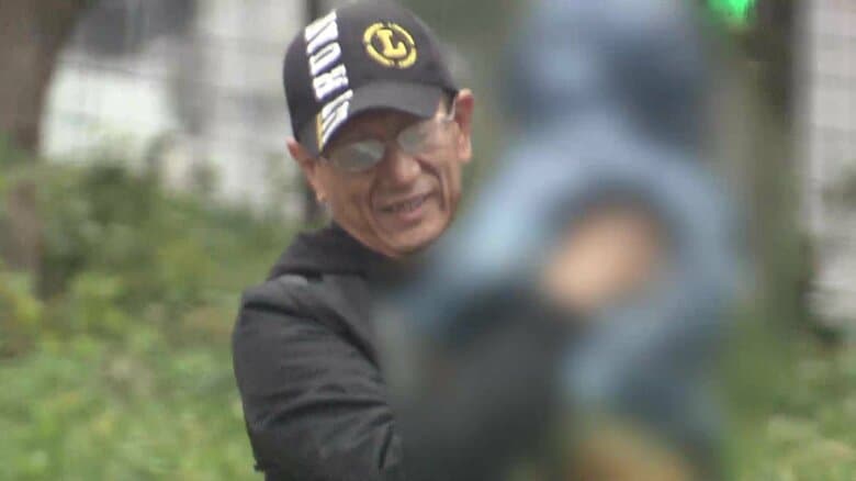 笑顔を浮かべ、子どもを抱きかかえるカミンスカス操受刑者