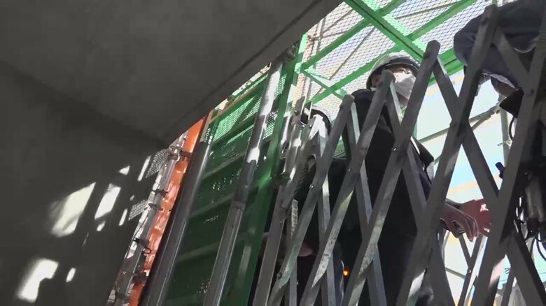 仮説のエレベータに乗りやや緊張気味の榎並アナウンサー