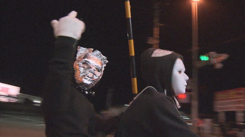 記者に対して中指を立てている