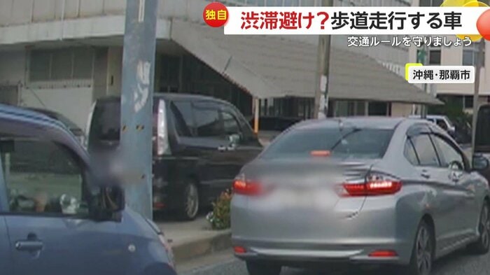 歩道を走る黒い車(視聴者提供)