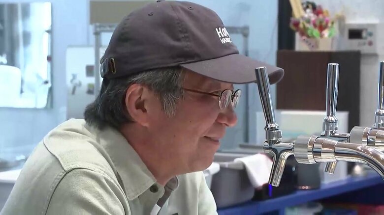 初仕込みビールの試飲の様子を見つめる醸造責任者の村上さん