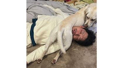 「おやじ様だぞ」寝ている飼い主の顔の上で後ろ足をサンド！自由な大型犬の姿が面白い…普段の仲を聞いた