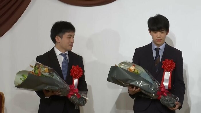 花束を受け取った菅井竜也八段(左)と藤井聡太六冠(右)