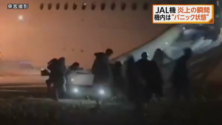 脱出シューターで避難する乗客ら