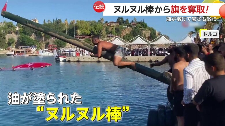 たっぷりの油が塗られた長い棒の先の国旗を取る「オイリー・マストコンテスト」