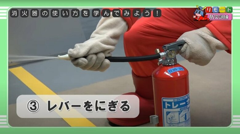 消火器の使い方（3）レバーをにぎる（提供：東京消防庁）
