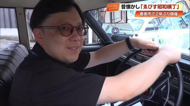 旧車に乗り笑顔の竹久記者