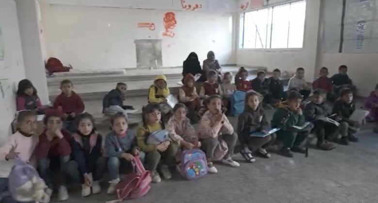 ガザ地区南部・ハンユニスのUNRWA避難所で机もない部屋で授業を受ける子どもたち(12月21日)