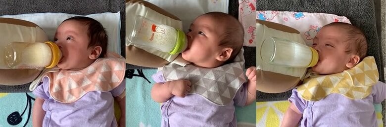 クッションを使って飲んでいる三つ子の表情アップ