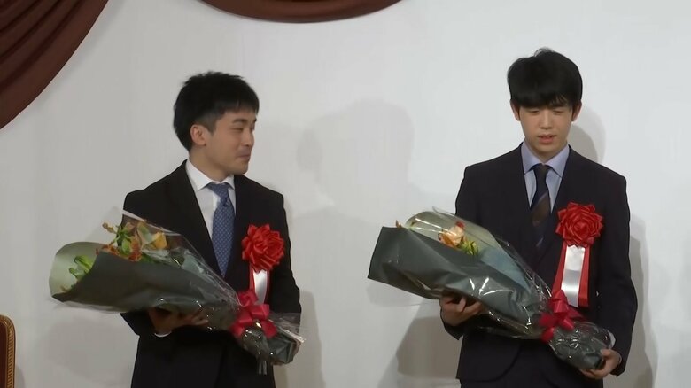 花束を受け取った菅井竜也八段（左）と藤井聡太六冠（右）