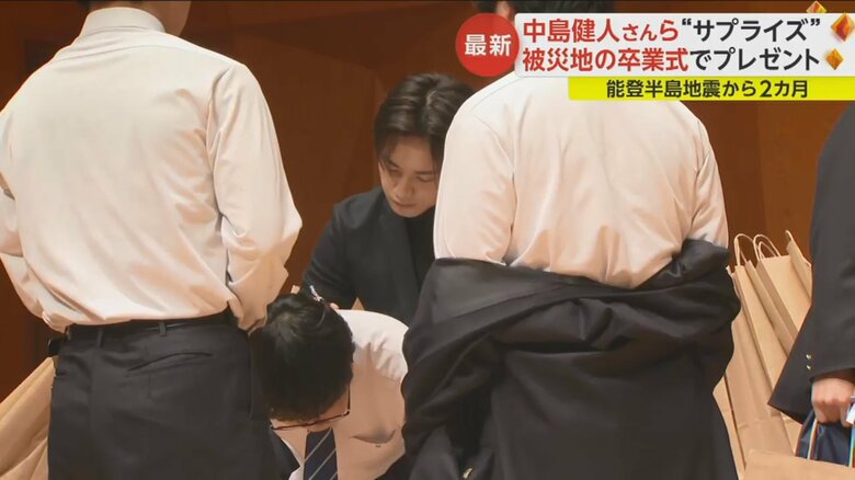 男子生徒の制服の背中にサインする中島健人さん