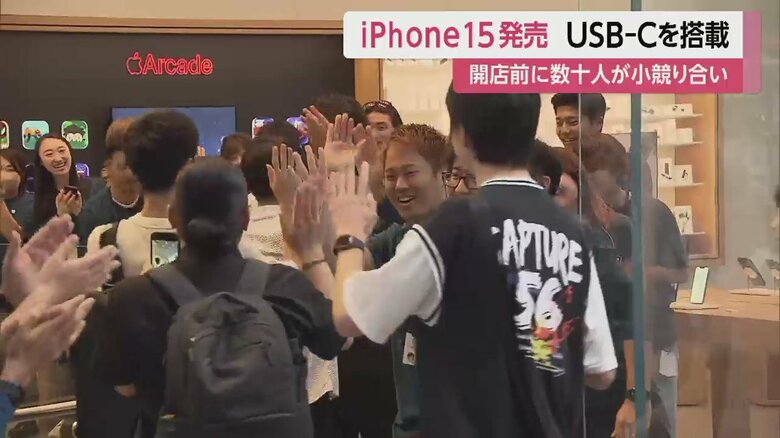 恒例のハイタッチをしながら、店内に入る客（Apple表参道店　22日午前8時）