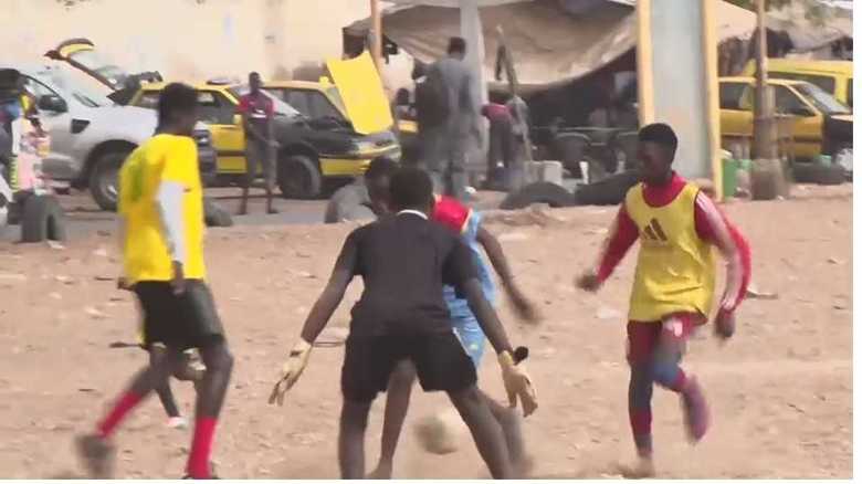 ビーチでは多くの人がサッカー