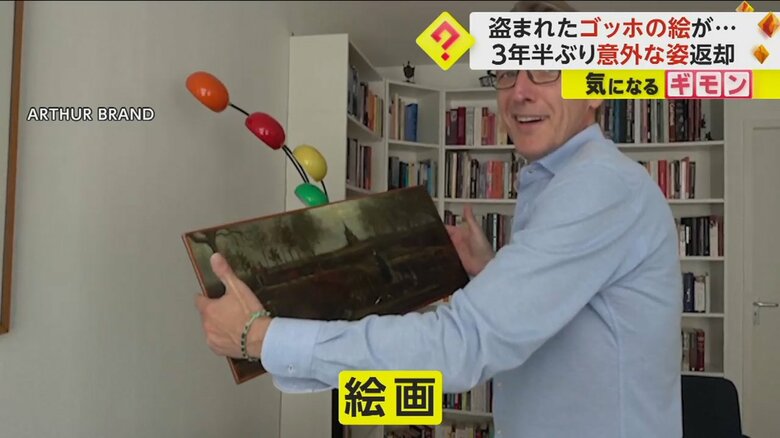 中から出てきた絵画を見て嬉しそうな男性