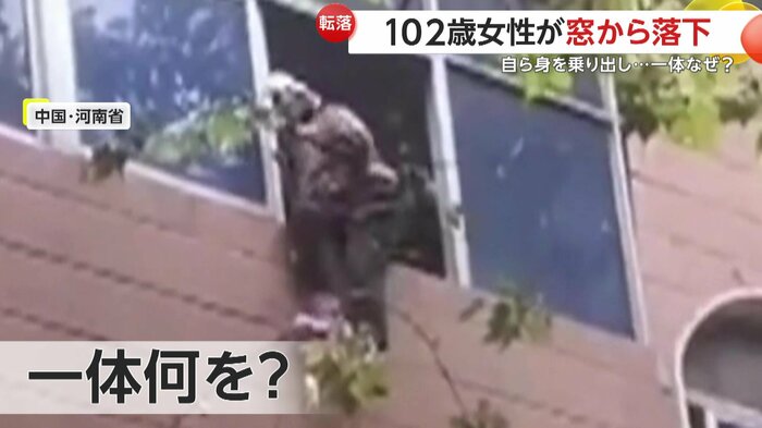 3階の窓に腰掛ける高齢女性