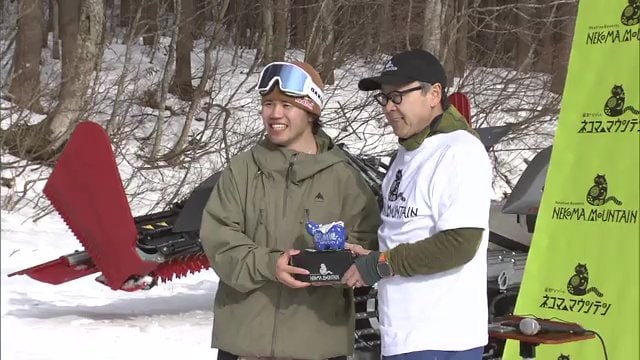 縁起物の赤べこを手に