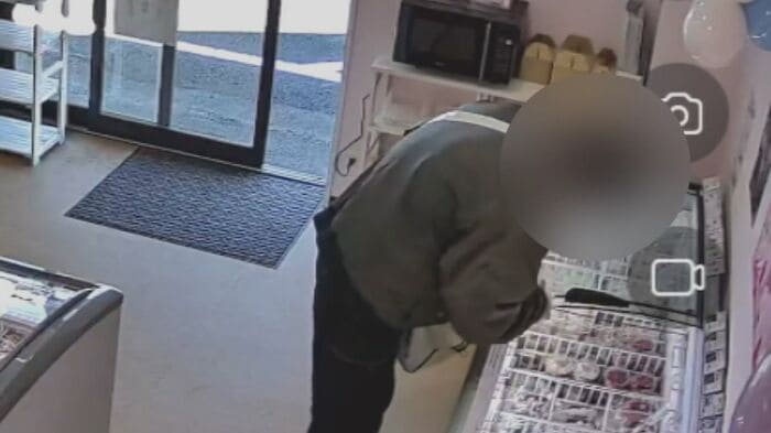 商品をバッグに入れる男