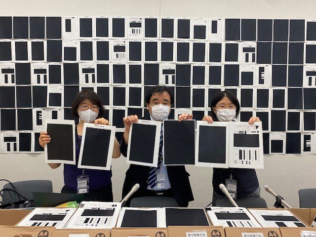 名古屋入管から送られてきた黒塗りの文書1万5千枚と遺族代理人の駒井知絵氏(左)と指宿昭一氏(中央)