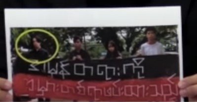 ほかの拘束者と共に横断幕を持たされた写真