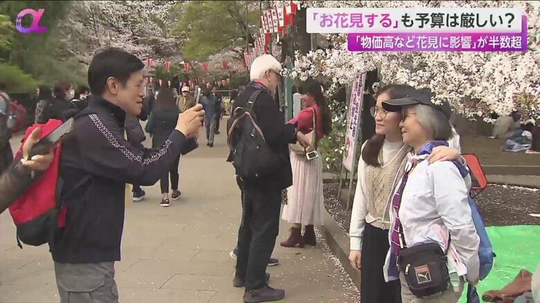 桜の前で記念撮影をする人