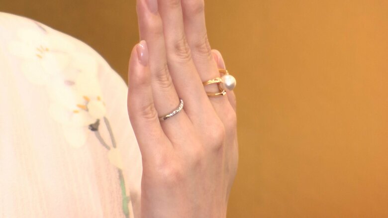 薬指に結婚指輪、人差し指に大きなパールの婚約指輪