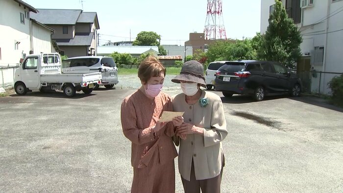 菊池市を訪れ、写真を見つめる丸山さん(左)と中野さん(右)