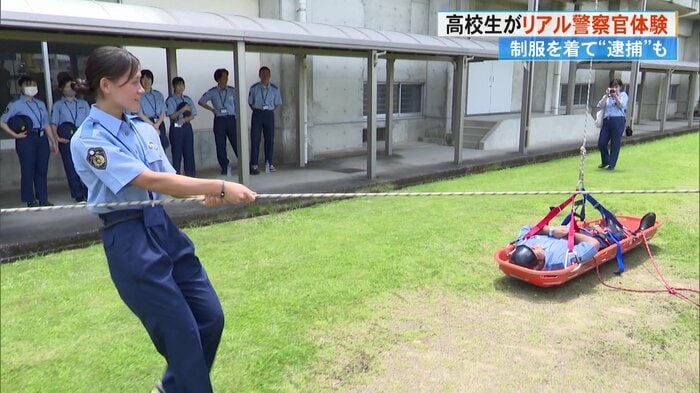 救護者を乗せた担架を高校生たちが引き上げる