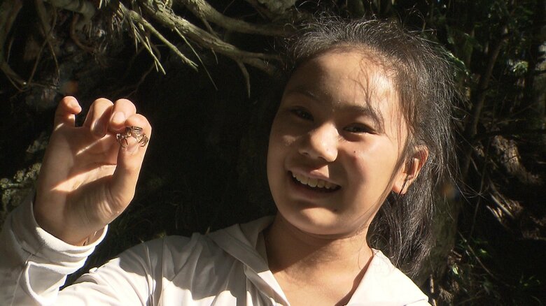 沢ガニを見つけて笑顔になる小学6年生の参加者