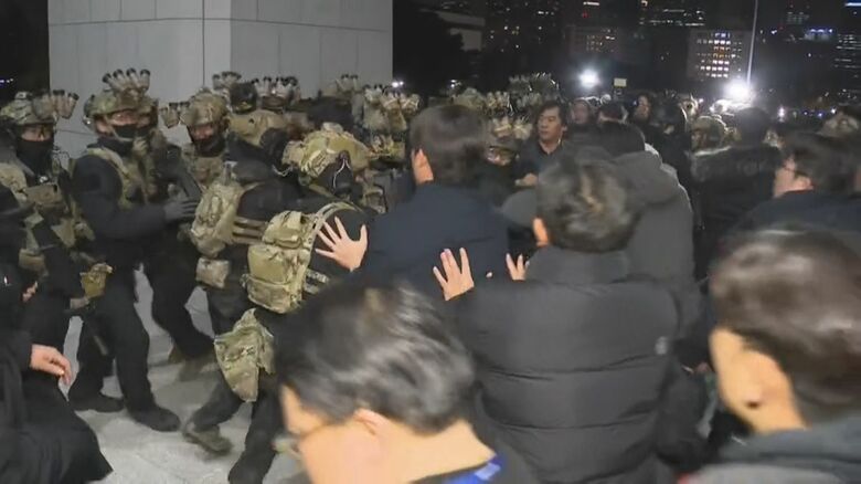 戒厳令を受け国会でもみ合いになる兵士と職員たち