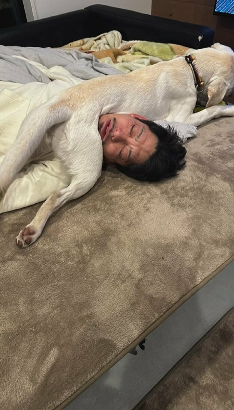 寝ている旦那さんの首元に乗るえまちゃん