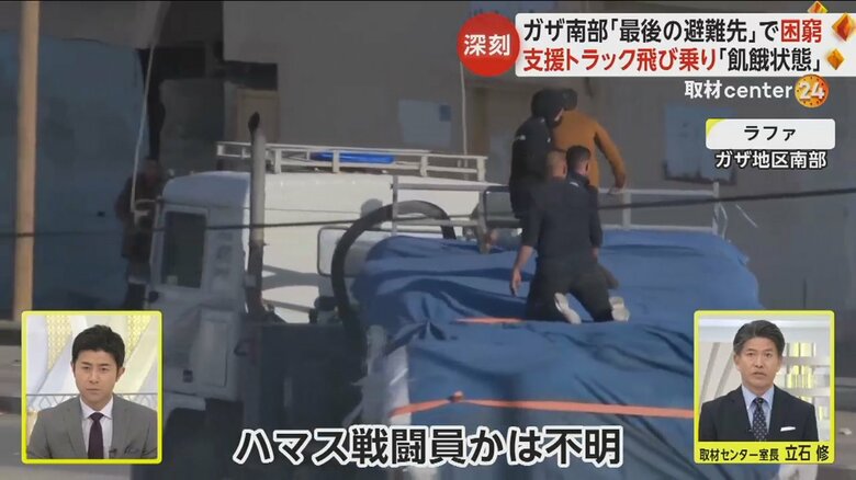 物資搬入のトラック上には、銃を持った人が載っている