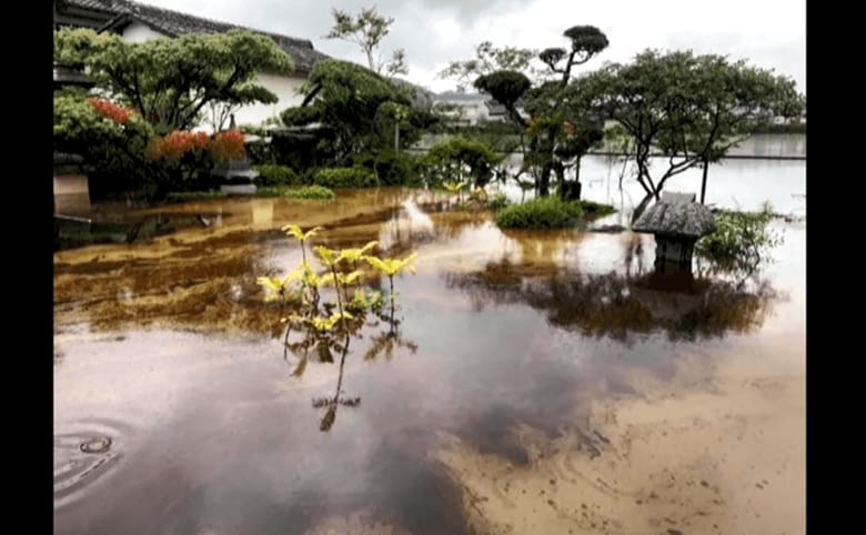 豪雨の被害で油まみれになった野口さんの自宅の庭