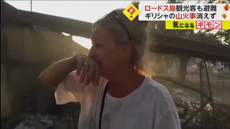 家が燃える光景を前に、涙を流す女性