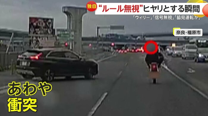 乗用車が近づくなかで危険運転を行うバイク(視聴者提供)