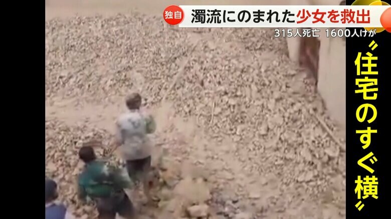 濁流が住宅のすぐ横にまで到達し、なす術なく立ち尽くす住民たち