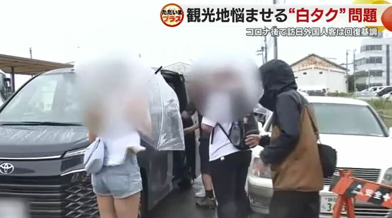 白タクとみられる車を取材する斉藤記者（右）