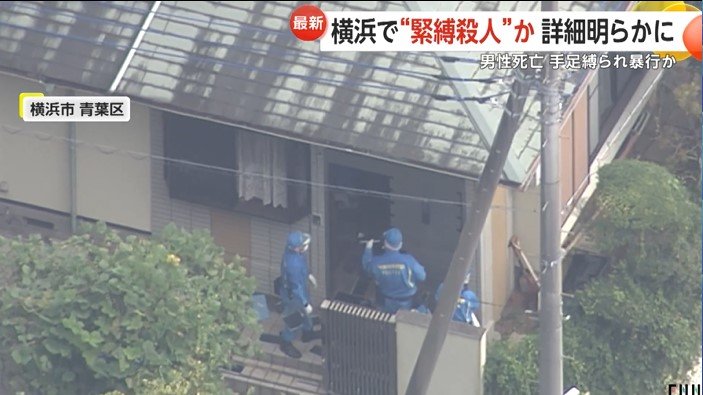 鑑識作業にあたる警察官ら。玄関脇の窓が開いているのが確認できる。