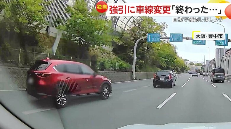 4車線の道路で左側から一気に車線変更してきた赤い車（5月10日、大阪・豊中市）
