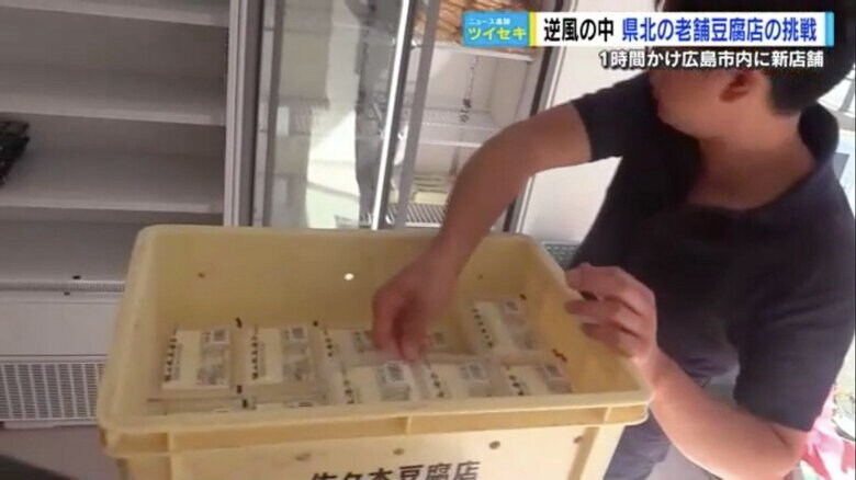 豆腐を棚に並べる佐々木社長