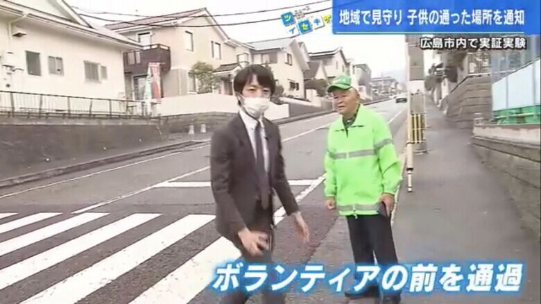 ボランティアの前を通過する五十川裕明記者