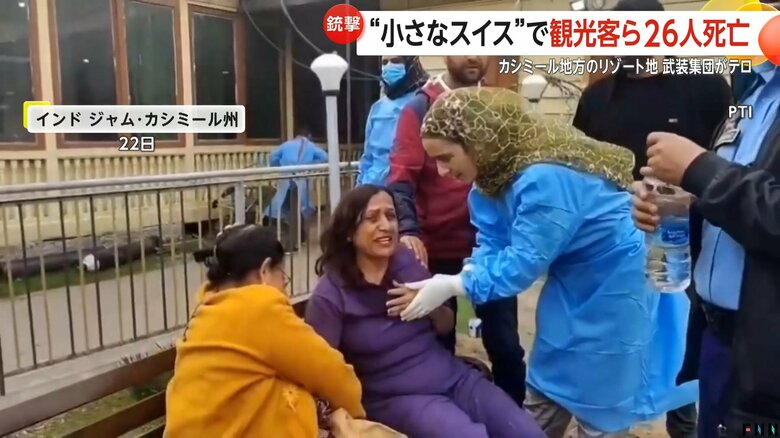 事件現場で苦しそうに胸を押さえる女性