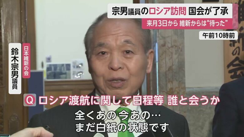 記者団の取材に応じる鈴木宗男委員。ロシア訪問は白紙の状態だという（26日 午前10時前）