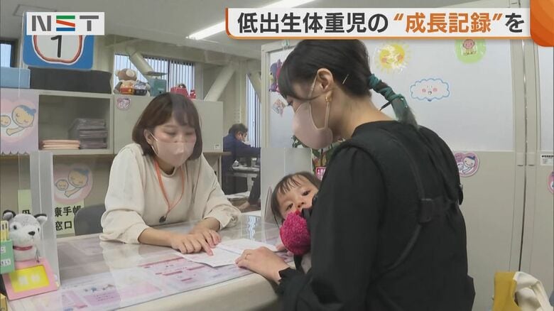 リトルベビーハンドブックを受け取る栞里さん親子